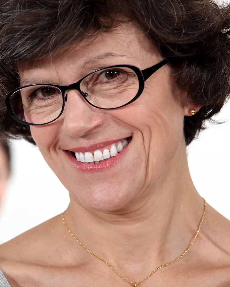 Smiling woman with glasses and a gray sweater